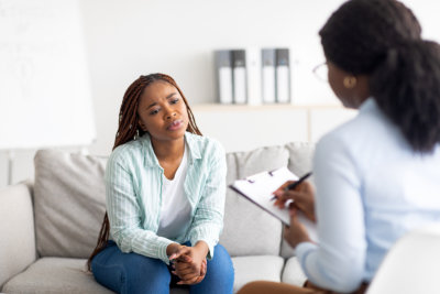 woman having counseling session with therapist at modern clinic